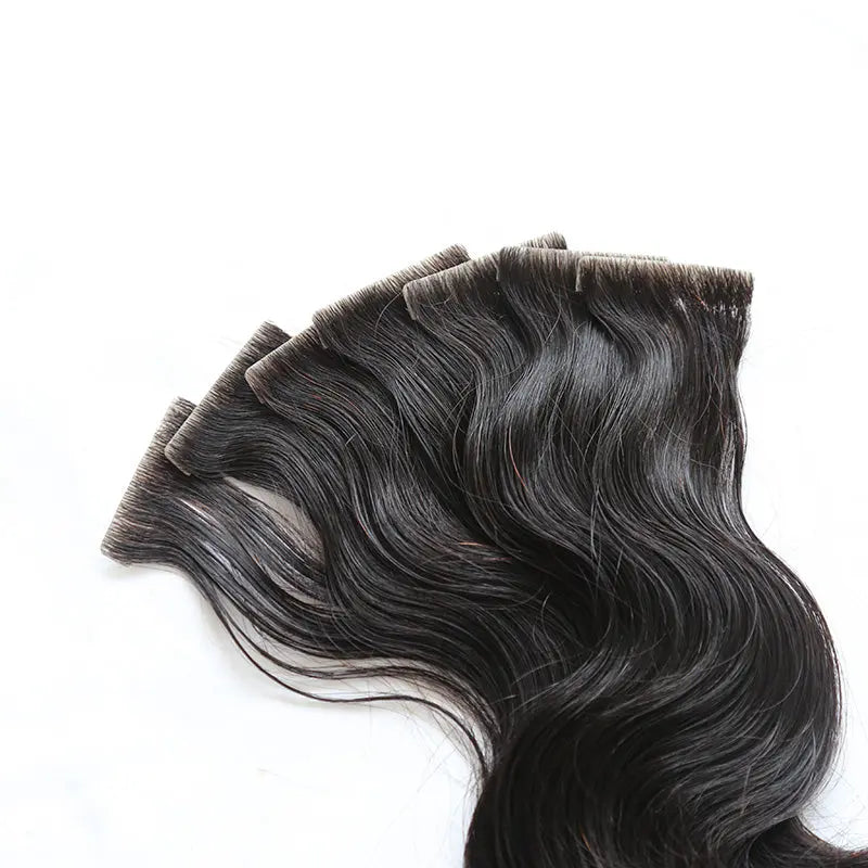Skin Weft tape-in extensions: Close-up of dark hair attached along a skin-weft edge