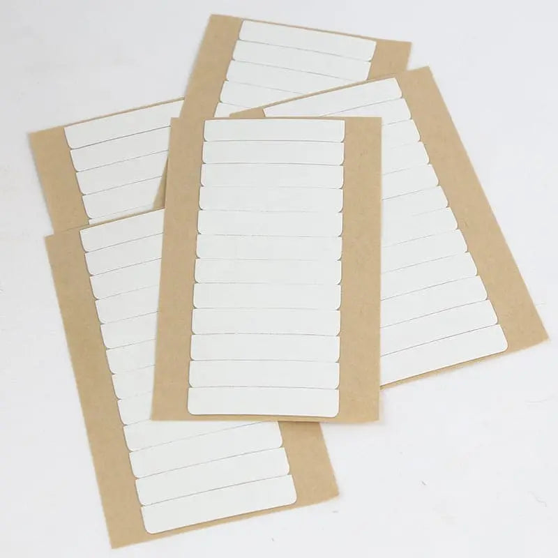 Replacement tape refills: Several sheets of white pre-cut replacement tape tabs